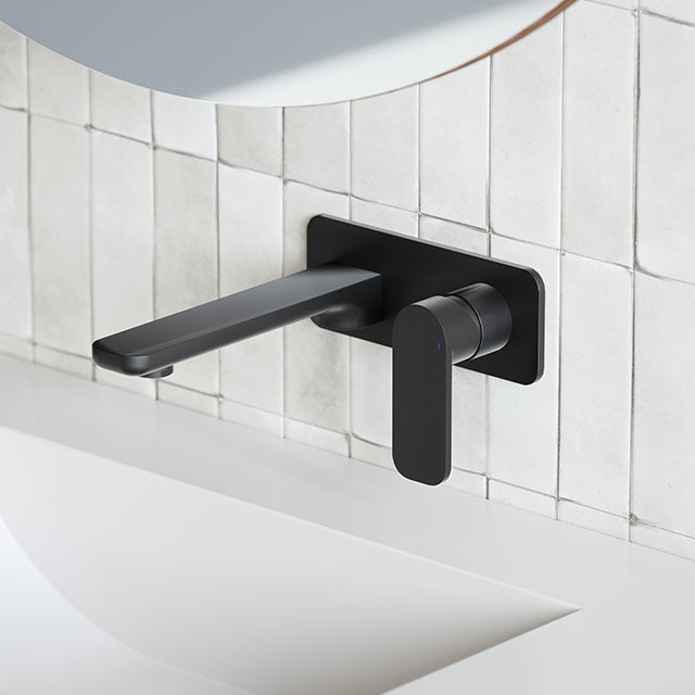 Caroma Luna black wall basin/bath mixer with paddle handle on tiled bathroom wall, side view