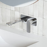 Caroma Luna chrome wall basin/bath mixer with flat spout and paddle handle, mounted above a white basin and tiled wall