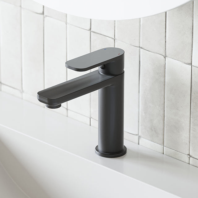 Caroma Luna black basin mixer tap, hob mounted with slim curved spout and paddle handle, shown on a vanity basin