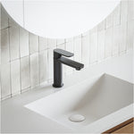 Caroma Luna black basin mixer tap on a white vanity basin with tiled splashback, modern bathroom setting