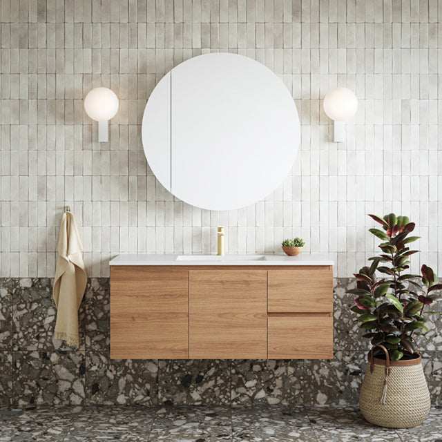 Caroma Luna black basin mixer on a timber vanity in a modern bathroom, front view with round mirror and wall lights