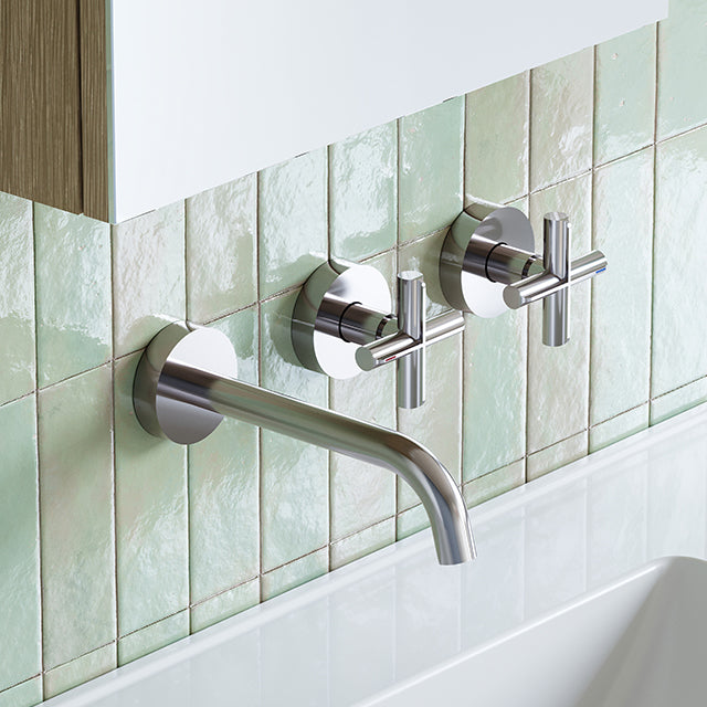 Phoenix Vivid Slimline Plus wall basin/bath set in chrome, with round wall taps and 180mm spout above a bath on green tiles