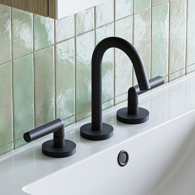 Phoenix Vivid Slimline Plus three-piece basin set in matte black on a white vanity with green tiled splashback