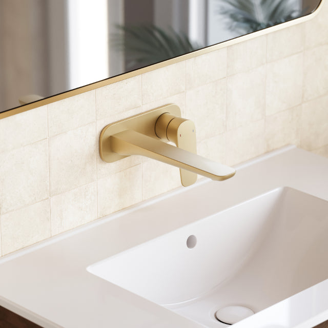 Caroma Contura II wall basin mixer in brushed brass, shown over a white basin with wall-mounted spout and lever handle