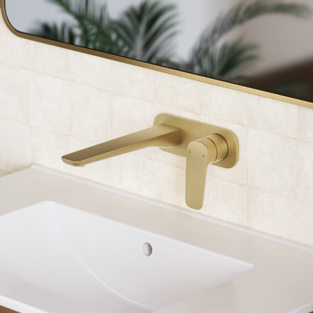 Caroma Contura II wall basin mixer in brushed brass, wall-mounted over a white basin with slim spout and lever handle