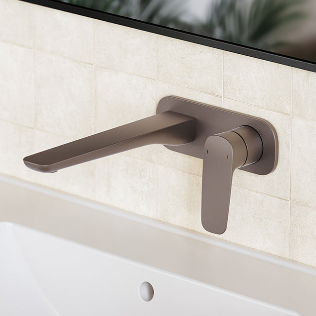 Caroma Contura II wall basin/bath mixer in brushed bronze, wall-mounted tap with extended spout on tiled bathroom wall.