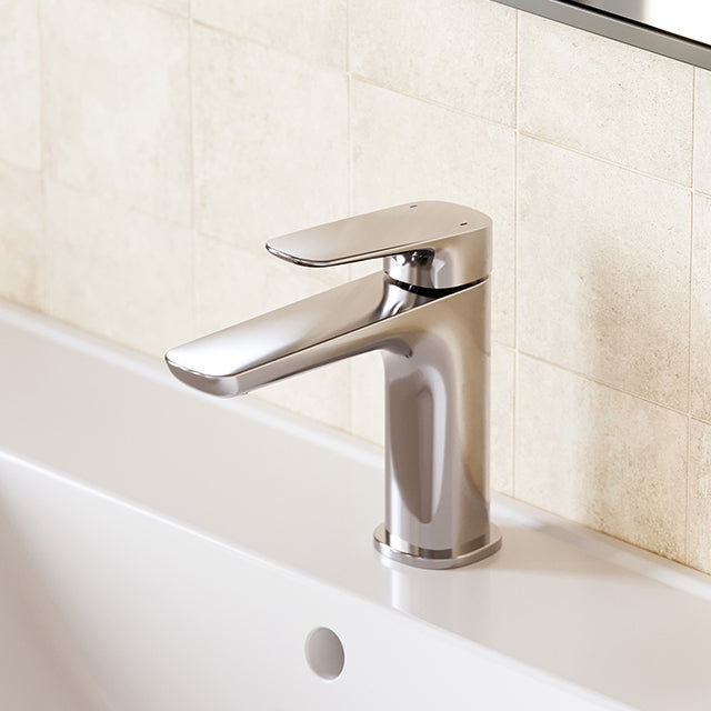 Caroma Contura II basin mixer tap in chrome, hob mounted over a white basin against beige tiled wall