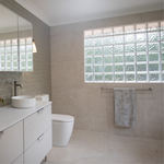Caroma Liano II double towel rail in brushed nickel, mounted on a tiled bathroom wall with a towel hanging