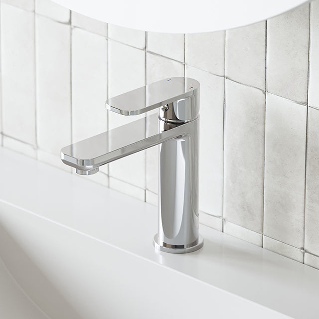 Caroma Luna basin mixer in polished chrome, hob mounted on a white basin against tiled wall
