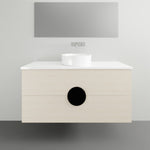 Timberline Oxbow wall hung vanity with white top and above counter basin, shown in pale woodgrain finish with round black handle accent