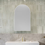 Timberline Church Frame shaving cabinet, arched mirrored white cabinet above a bathroom vanity with tiled wall backdrop