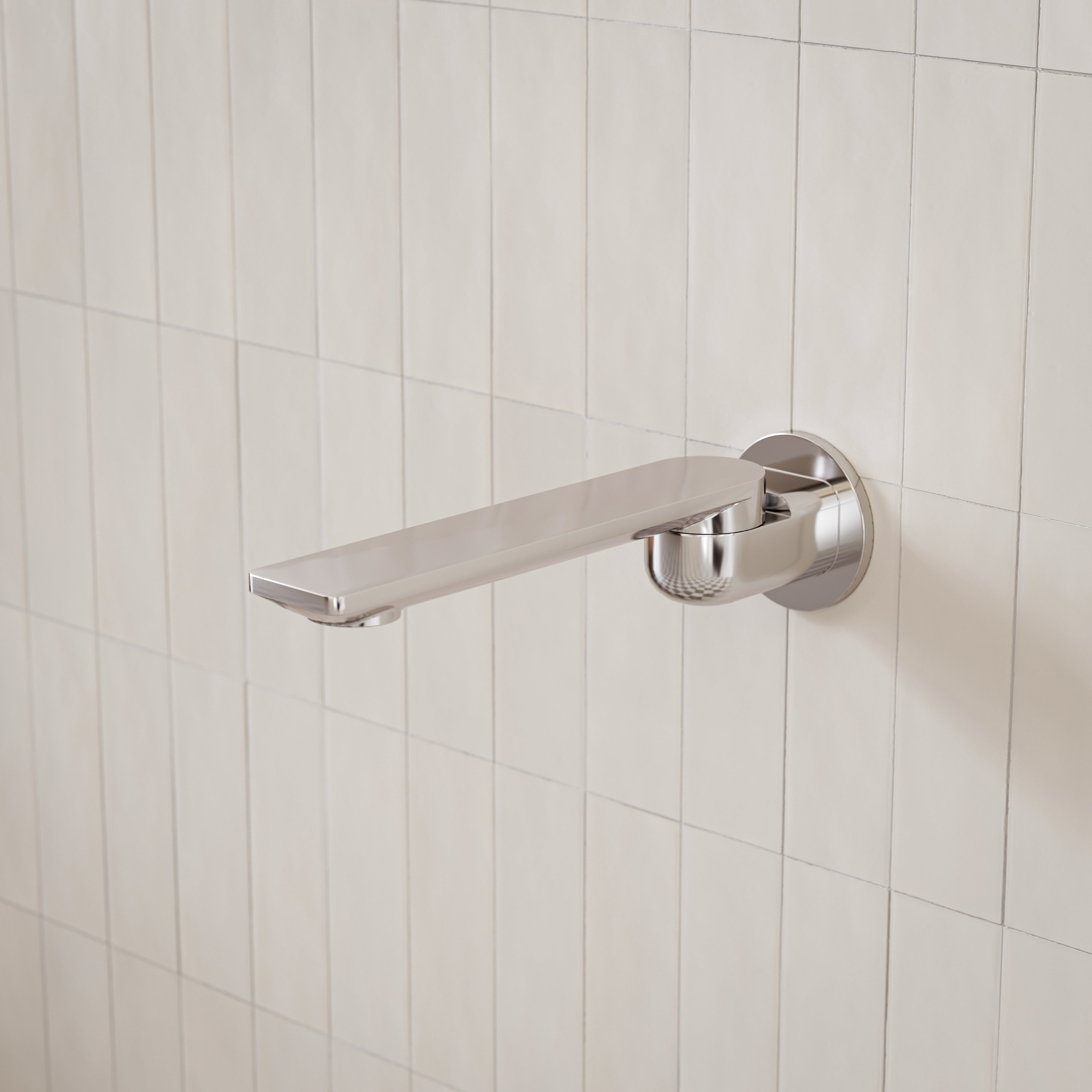 Caroma Urbane II round wall-mounted basin/bath outlet in polished chrome on tiled bathroom wall