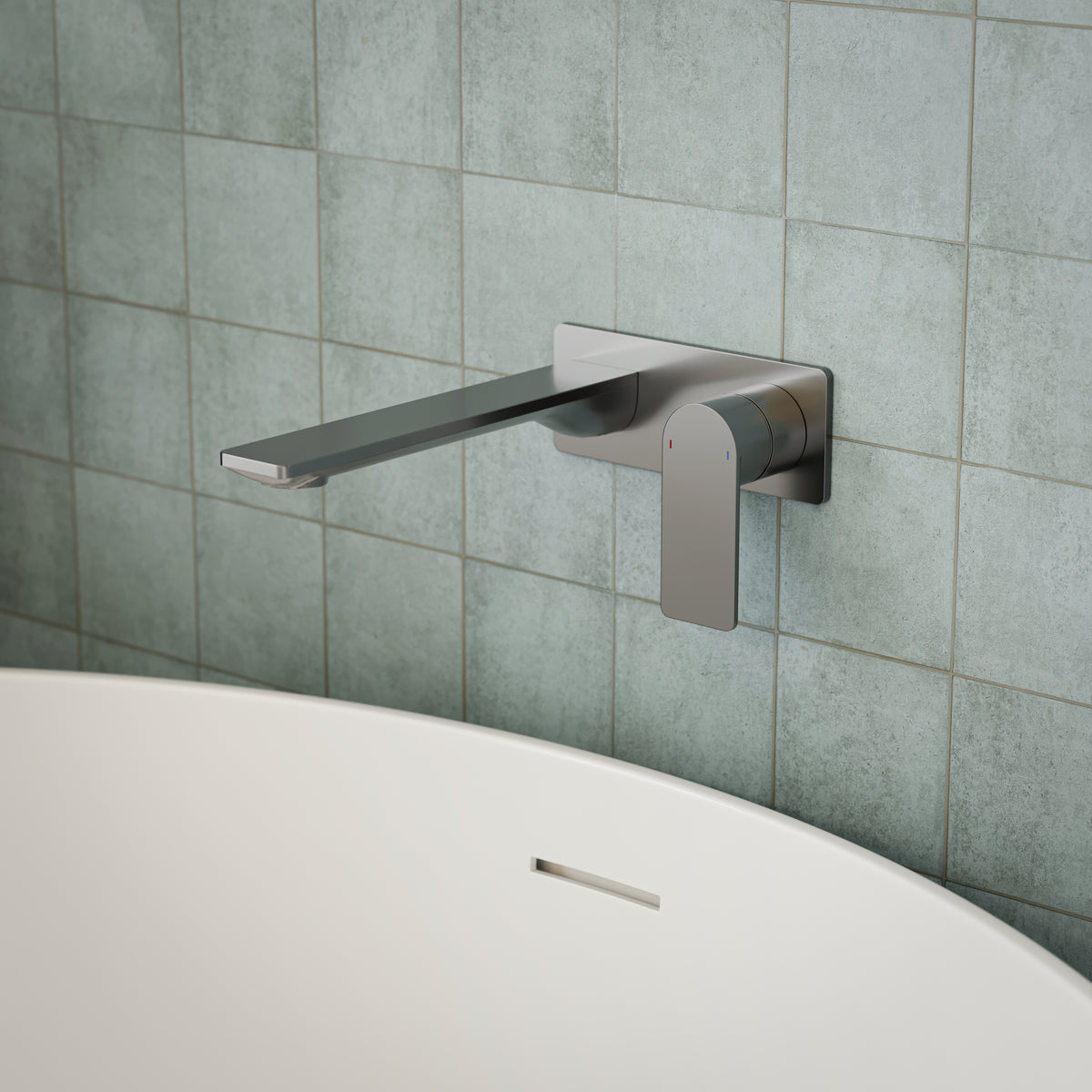 Caroma Urbane II wall-mounted basin/bath mixer in gunmetal, rectangle design, shown over a bath against tiled wall