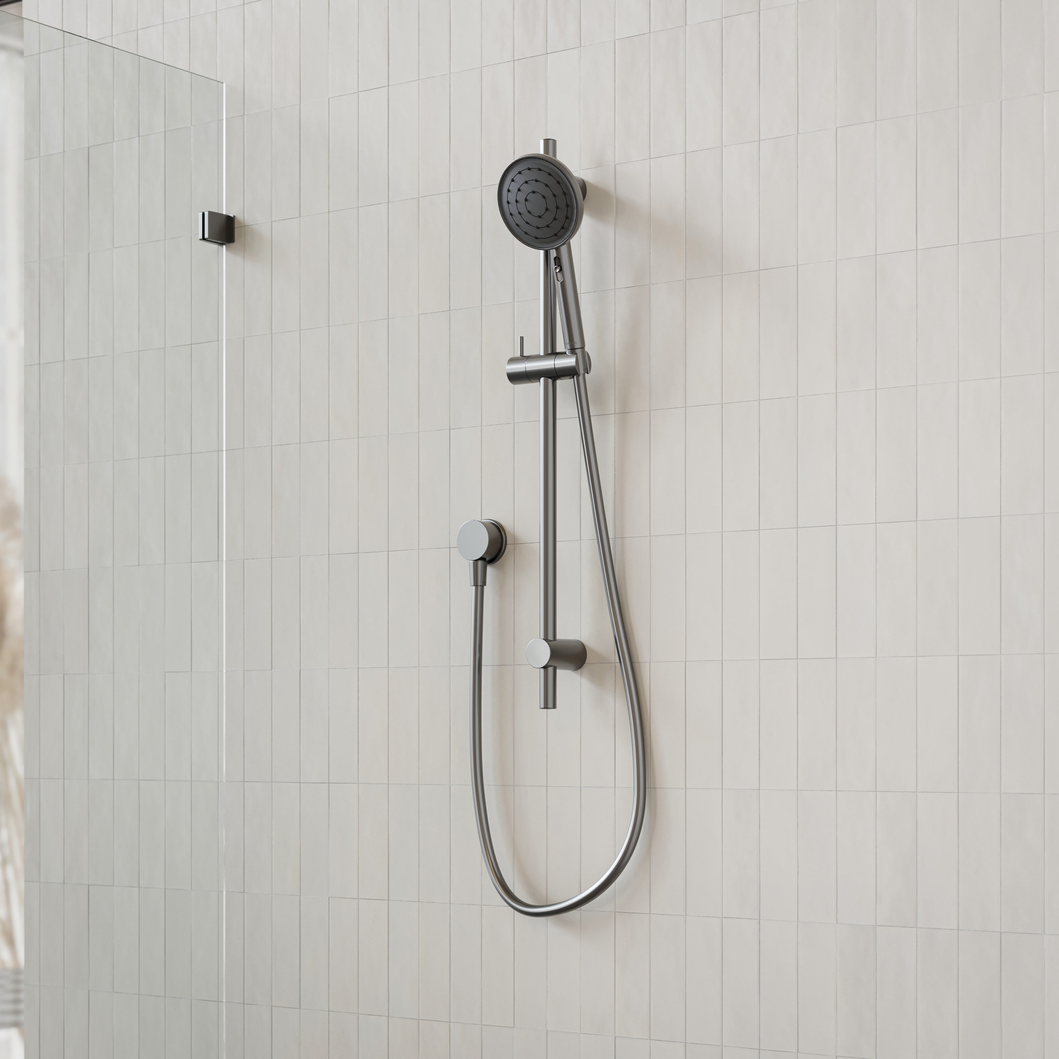 Caroma Urbane II gunmetal rail shower with round handset and hose on tiled bathroom wall