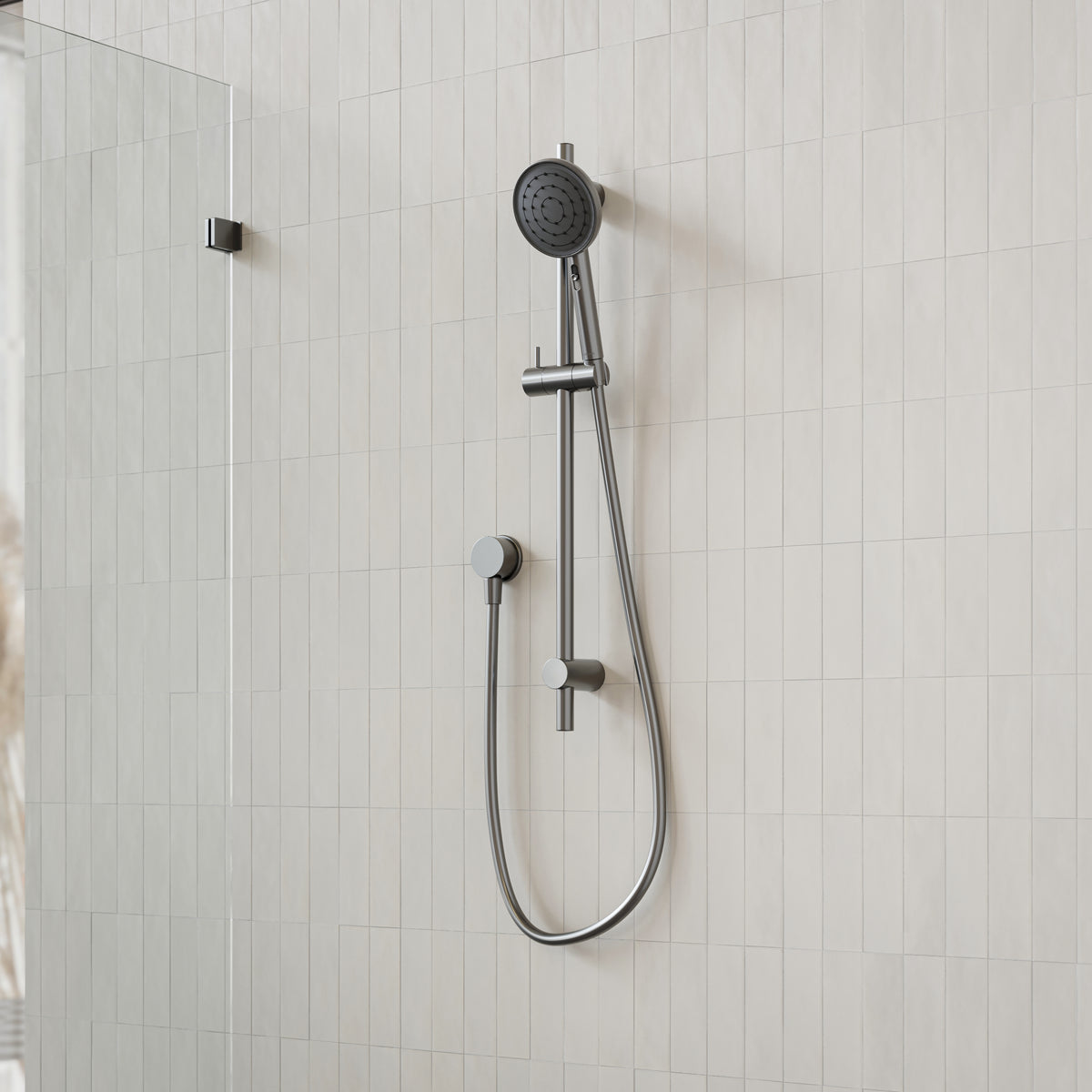 Caroma Urbane II gunmetal rail shower with round handset and hose on tiled bathroom wall