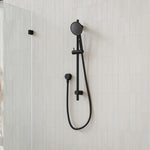 Caroma Urbane II matte black rail shower with round handset on white tiled bathroom wall