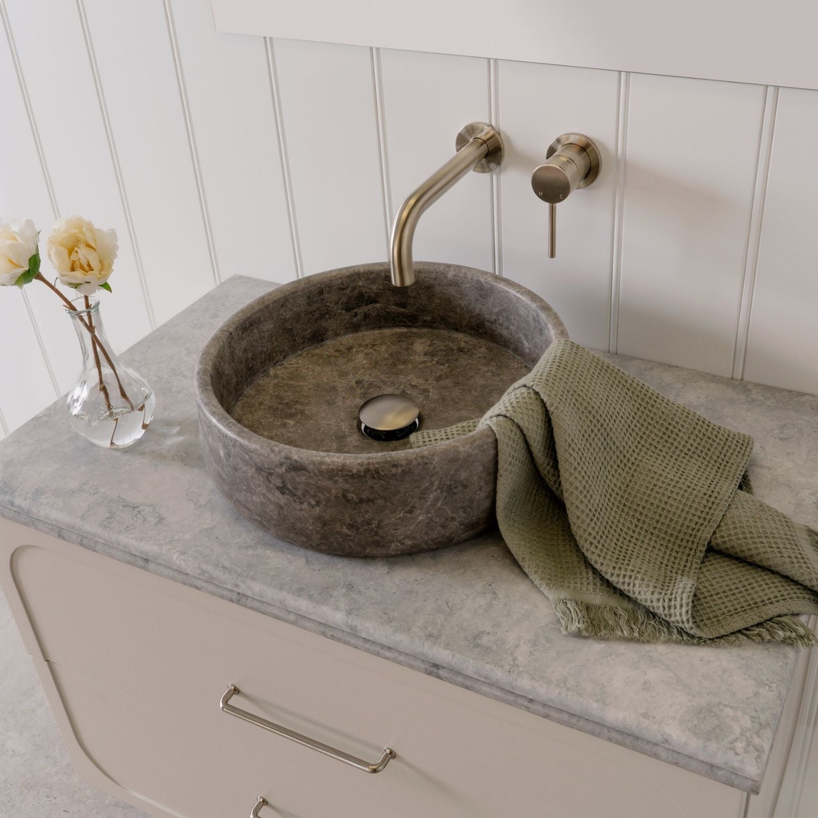 ADP Arlo round above counter stone basin in Manyana grey on a vanity benchtop, with wall-mounted tapware