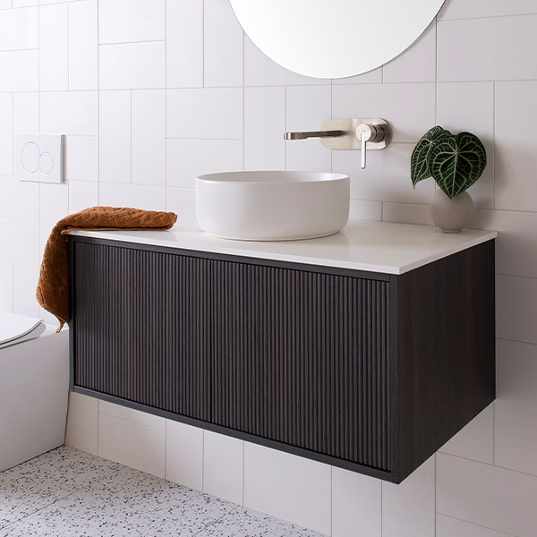 ADP Clifton wall-hung vanity in dark woodgrain with white Caesarstone top and round basin, shown in a bathroom.