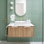 ADP Clifton wall-hung ensuite vanity in woodgrain with white top and round basin, shown in a green tiled bathroom setting