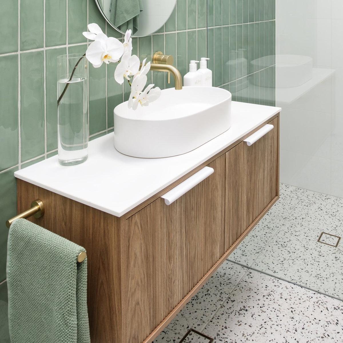 ADP Clifton wall-hung ensuite vanity with white top, oak woodgrain front and oval basin in a green tiled bathroom