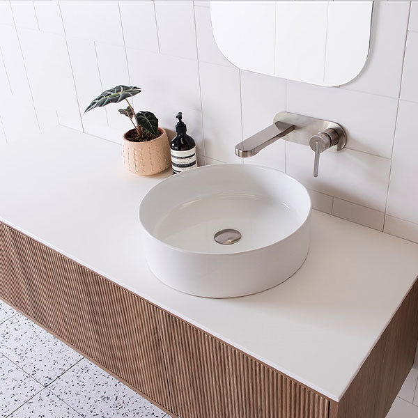 ADP Clifton wall-hung vanity with white Caesarstone top, fluted woodgrain front and centre basin in bathroom setting
