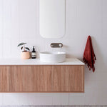ADP Clifton wall-hung vanity with white Caesarstone top, vertical woodgrain finish and round above-counter basin