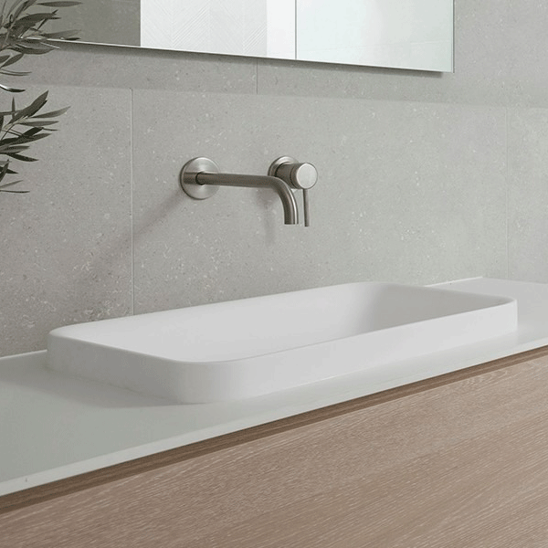 ADP Faith rectangular solid surface basin in white, sitting above a vanity against grey tiled wall, matte finish