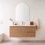 ADP Glacier Lite wall hung vanity with woodgrain finish and white top, centre basin, doors and drawers in bathroom setting