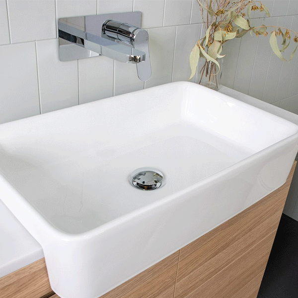 ADP Lino white semi-recessed ceramic basin with rectangular bowl and chrome wall mixer over timber vanity