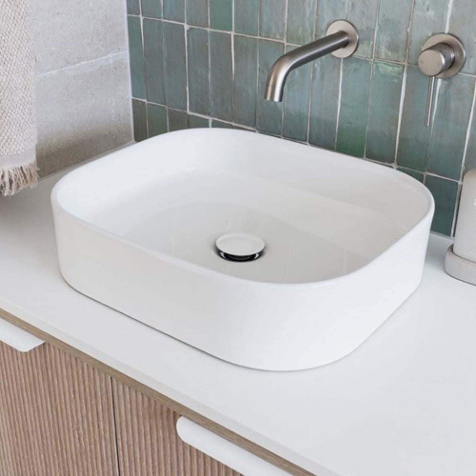 ADP Louie matte white rectangular above counter bathroom basin on a vanity, with chrome wall spout in a bathroom setting