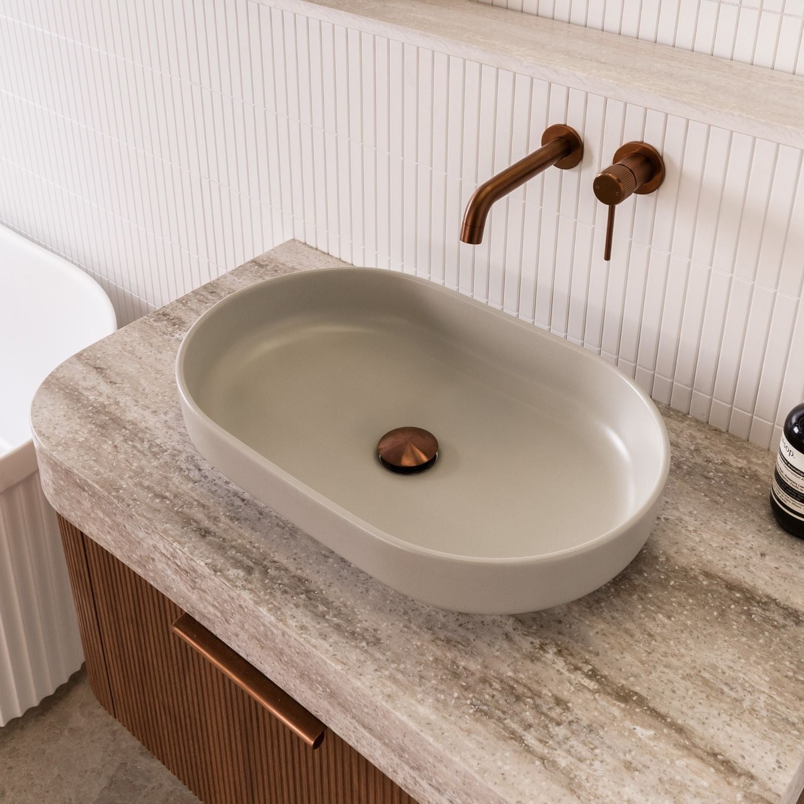 ADP Marilyn oval above counter basin in matte concrete on a bathroom vanity with copper tapware