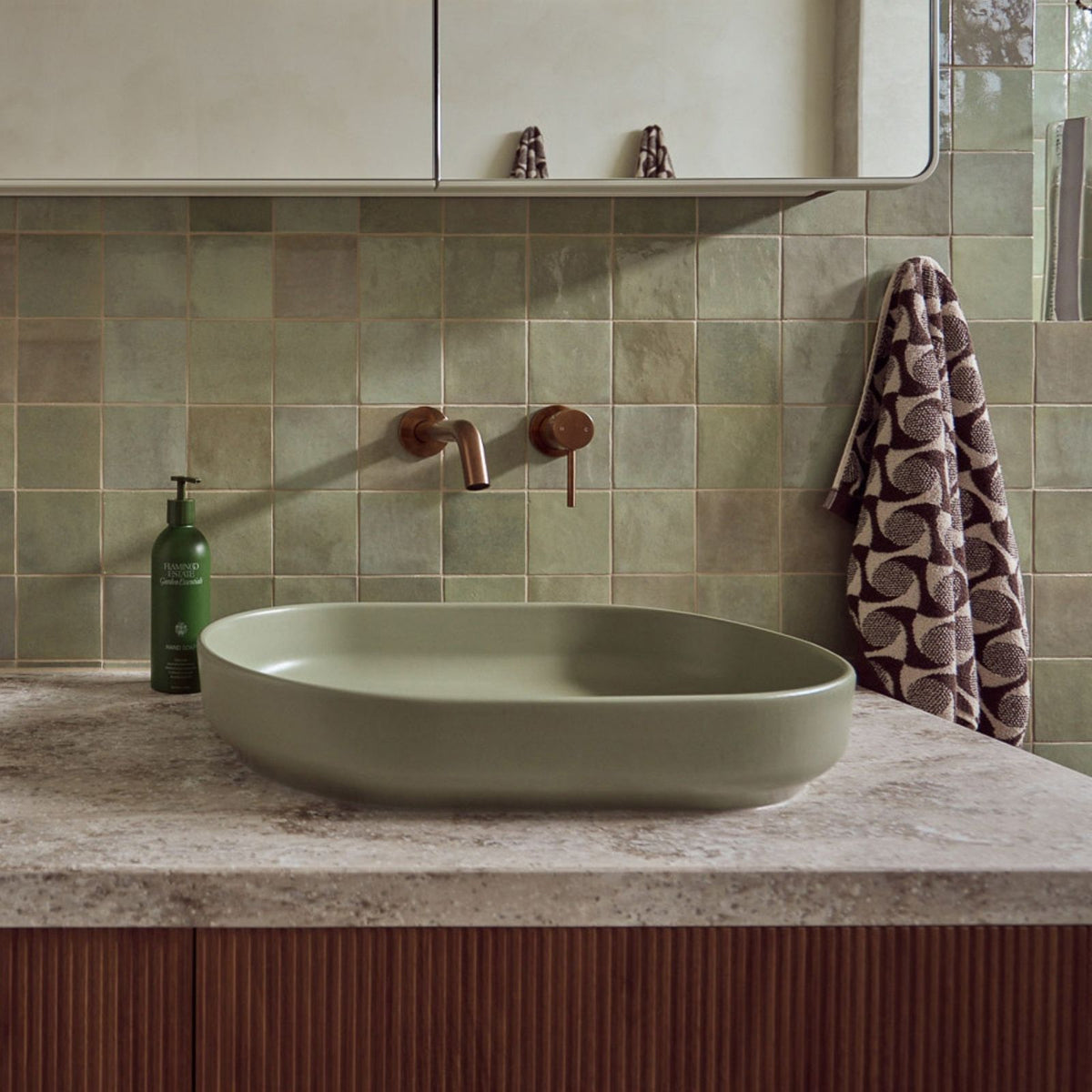 ADP Marilyn oval above counter basin in matte olive on a bathroom vanity with wall-mounted tapware and green tiled splashback