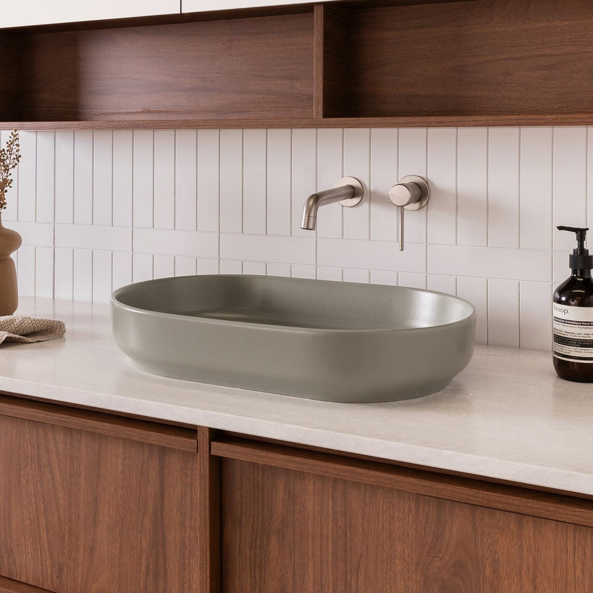 ADP Marilyn matte olive oval above-counter bathroom basin on a timber vanity with wall-mounted tapware.