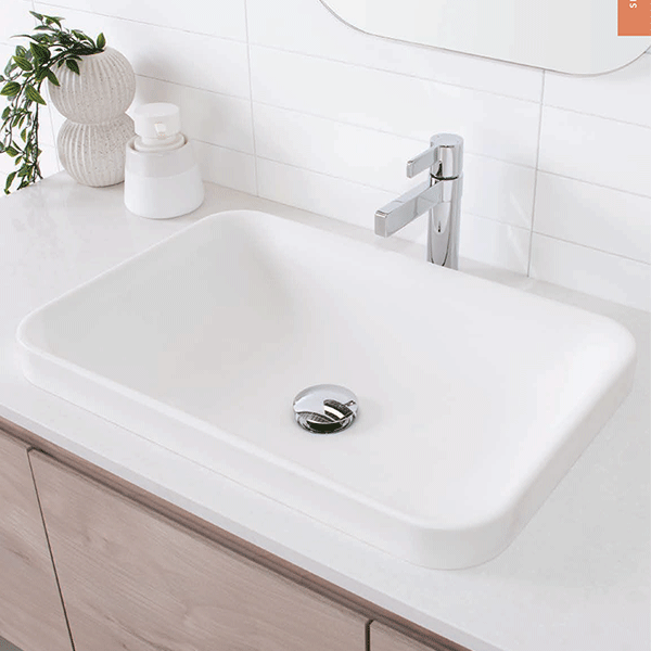 ADP Pride white solid surface semi-inset basin with rounded corners, shown installed on a vanity with mixer tap