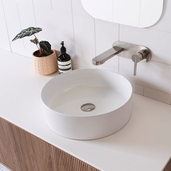 ADP Robbie round white above counter basin on vanity with wall-mounted mixer tap, lifestyle view