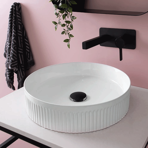 ADP round fluted above counter basin in gloss white, shown on a vanity with matte black tapware and waste.