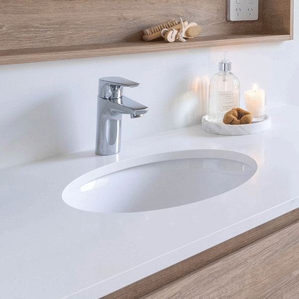 ADP Sincerity gloss white oval undermount bathroom basin set into a white vanity benchtop with chrome tap, lifestyle view