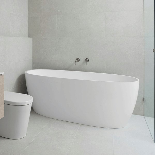 ADP Submerge oval freestanding bath in white gloss, shown in a modern bathroom setting with toilet and tiled walls
