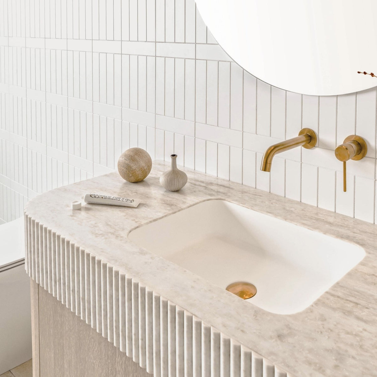 ADP Surry Imperial wall hung vanity with fluted edge top, matte white basin and brushed brass tap in a white tiled bathroom