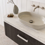Round marble-look vanity benchtop with integrated basin, shown on a bathroom vanity with brushed nickel tapware and white panelling