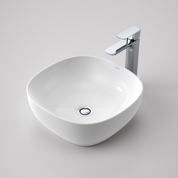 Caroma Artisan white above counter basin, curved square shape, with chrome waste, front view on a grey background