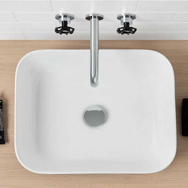 Caroma white gloss rectangular above-counter basin with rounded corners and chrome waste, top view on vanity