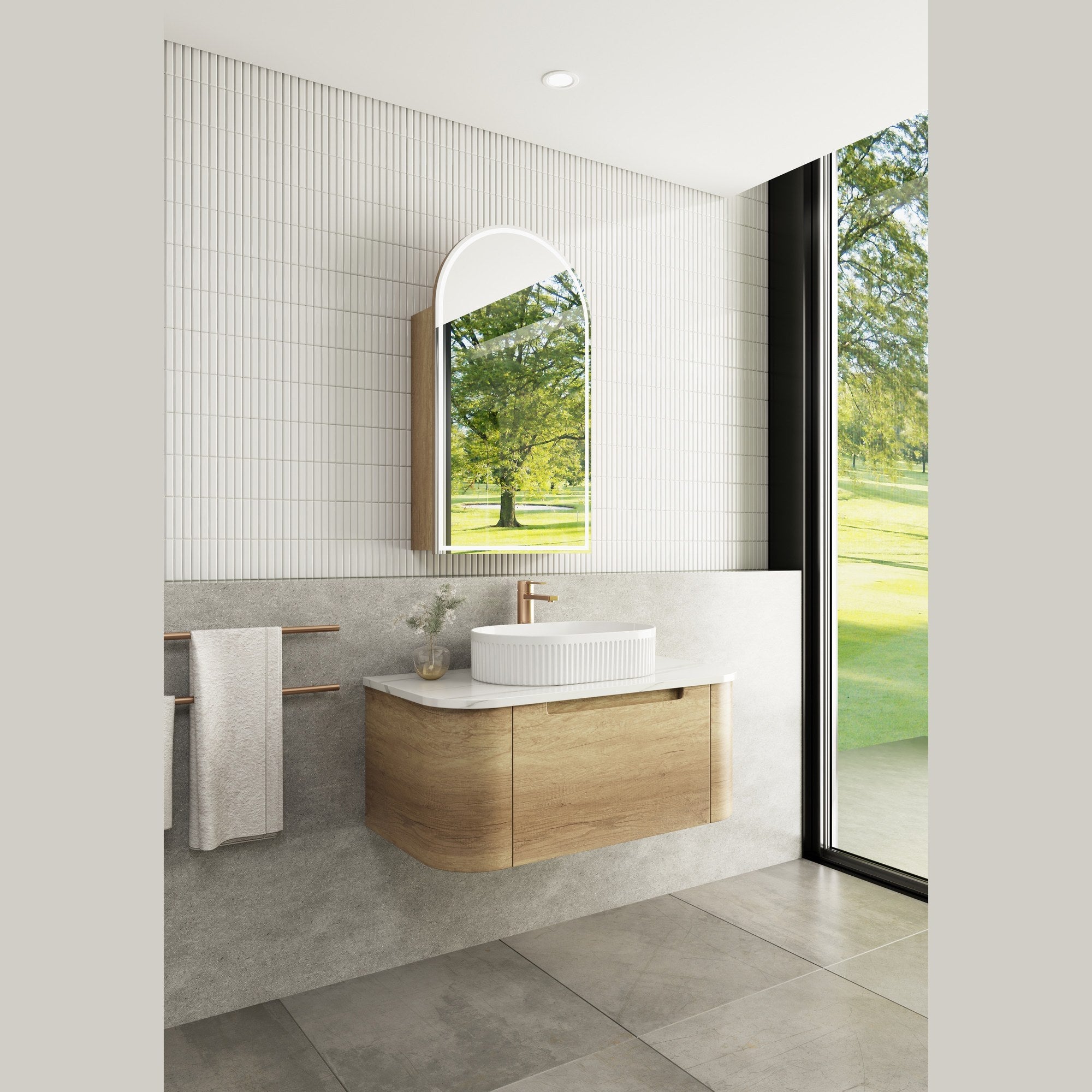Aulic Carita Curve wall hung vanity in woodgrain, shown in a bathroom with curved ends and white top, basin and arch mirror