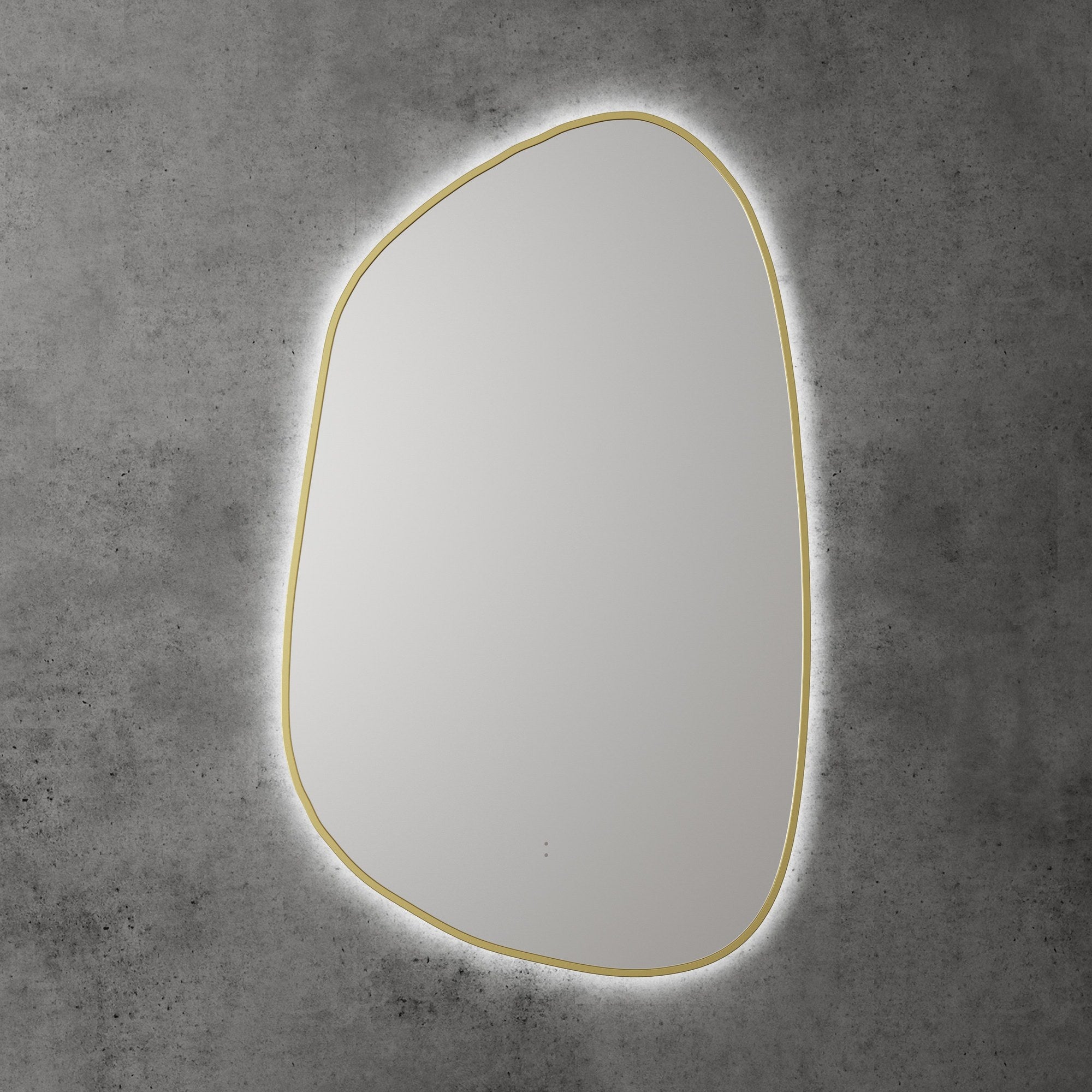 Aulic Tarcoola asymmetric LED mirror with brushed gold frame and backlit glow against a concrete wall