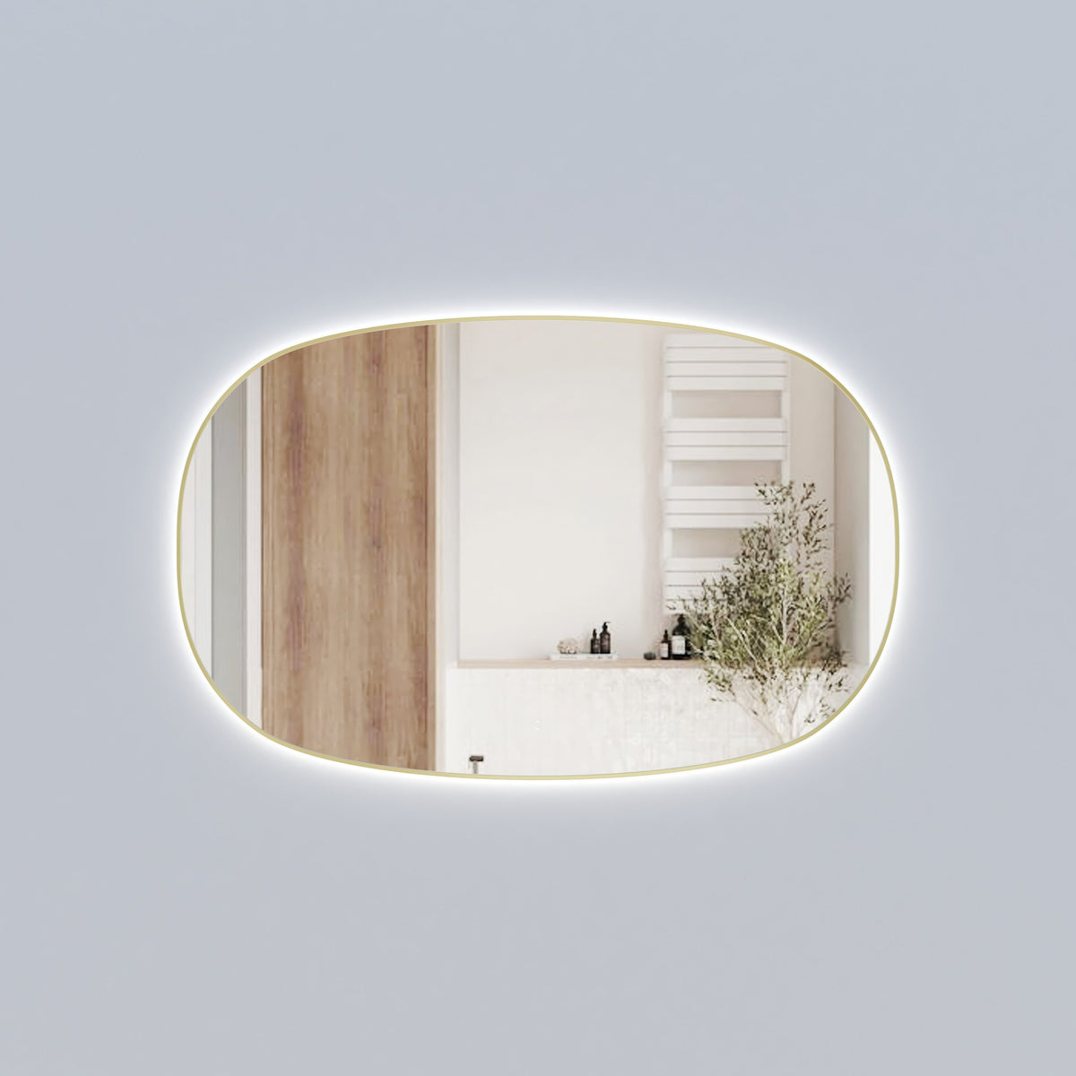 Aulic Valmont horizontal LED mirror in brushed gold, rectangular with rounded corners and backlit glow, shown in a bathroom setting