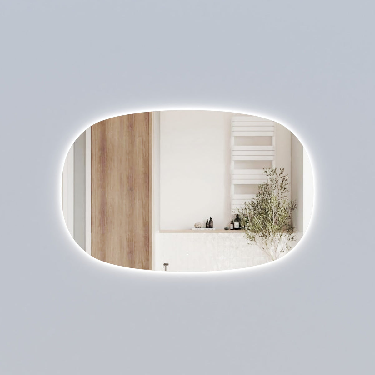 Aulic Valmont horizontal LED mirror, oval-edged with backlit glow, shown in a bathroom setting