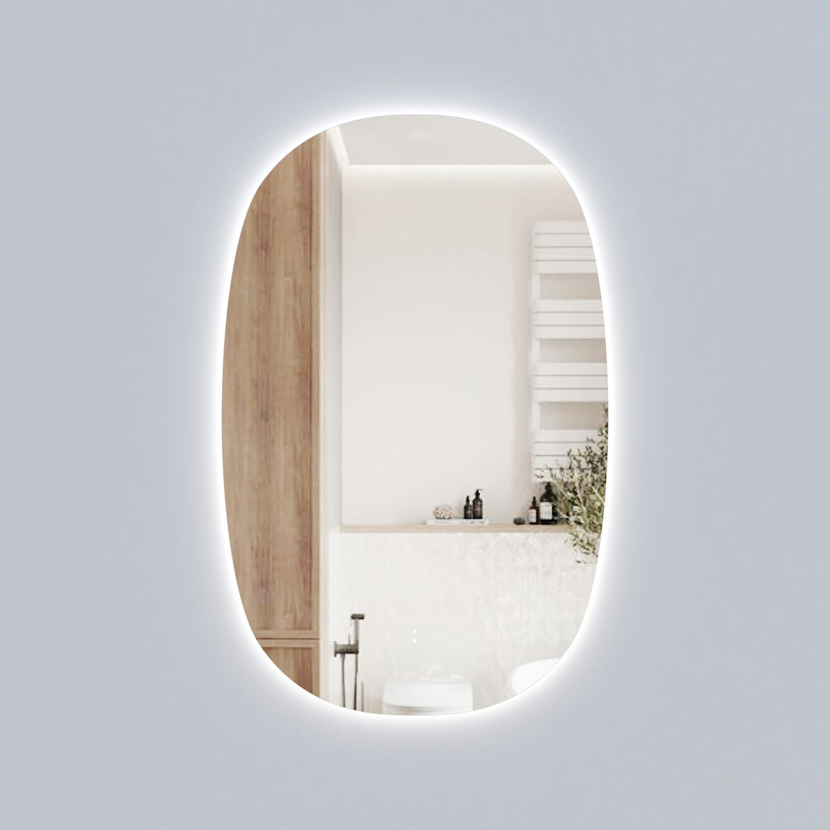 Aulic Valmont vertical LED mirror with rounded top and bottom, frameless oval-like shape, shown lit in a bathroom setting