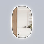 Aulic Valmont vertical LED mirror with black frame, tall rounded rectangle wall mirror with backlit glow, in bathroom setting