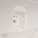 Aulic Valmont vertical LED mirror with rounded rectangle shape, shown wall mounted with soft backlit glow in a tiled bathroom