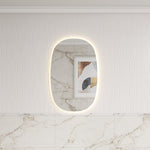Aulic Valmont vertical LED mirror with soft rounded rectangle shape and glowing backlit edge, shown in a bathroom setting